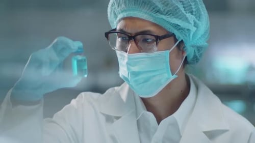 Medical Researcher Examining Blue Liquid in Glass Vial