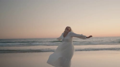 Woman Dancing on Beach at Sunset