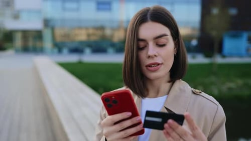 Woman Uses Phone and Credit Card in City
