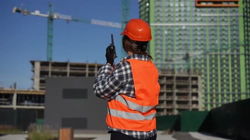 Woman Construction Worker Points in Urban Setting
