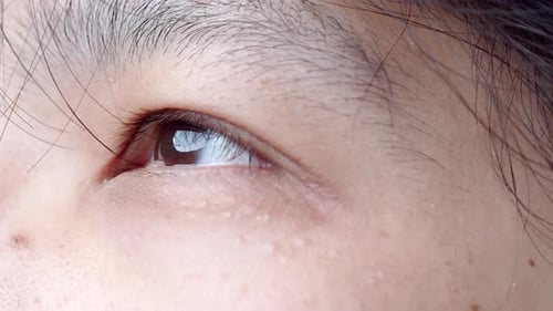 Close up of Asian Man's face. Attractive boy with beautiful eyes. Caucasian young male model with ey