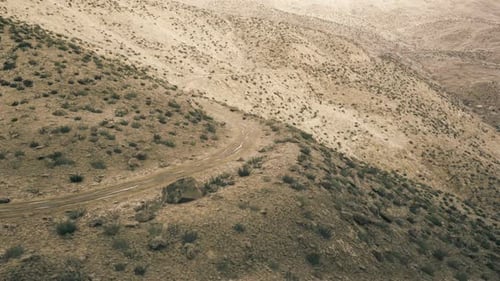 Sentier sinueux et calme au milieu d'une végétation clairsemée et de couleurs douces dans des collines isolées