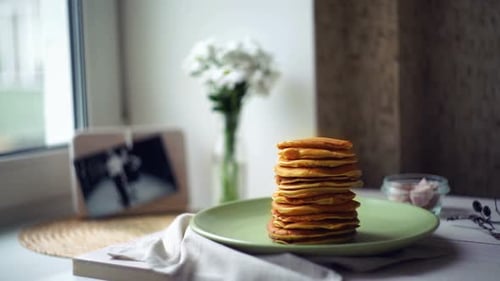 Stack of pancakes on green plate