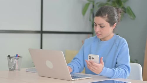 Young Adult Works with Laptop and Mobile Phone