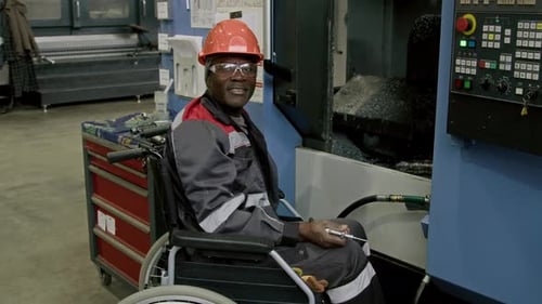 Portrait of Smiling Technician in Wheelchair with Air Blow Gun in Plant