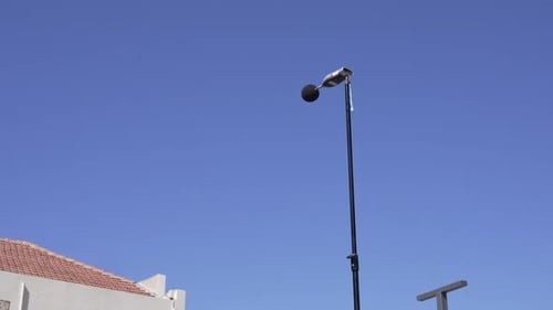 Foto ampla de um medidor de nível de som elevado no céu para registrar os níveis de som.