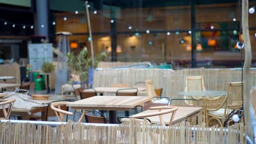 Empty terrace of a restaurant or bar, empty wooden tables and seats during Covid-19 Coronavirus pand
