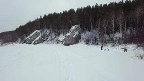 This is a Beautiful Snowy Landscape Featuring a Peaceful Forest and a Scenic Riverbank Scene Stock