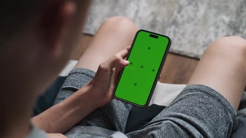 Kaukasischer Teenager scrollt Handy mit Chroma-Key-Modell