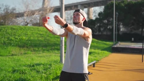 Man Stretching Arms Before Workout in Park