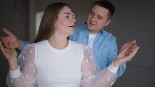Man Surprises Woman Covering Eyes in Indoor Setting