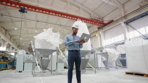 Chief Engineer With Laptop On Factory Analyzes The Production Process