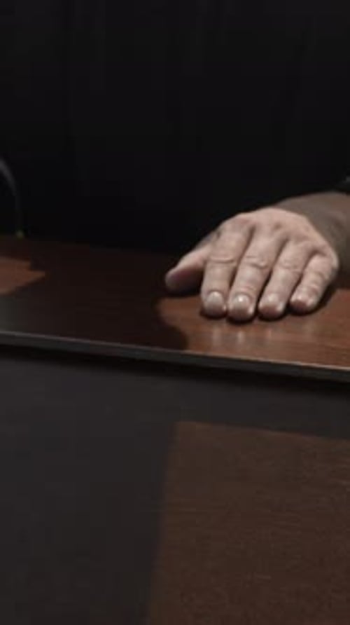 Man Resting Head on a Brown Desk
