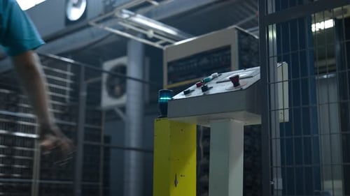 Arbeiter, der den Werksmechanismus startet, den Hebel zieht, den technologischen Arbeitsprozess der Maschine. Hersteller S
