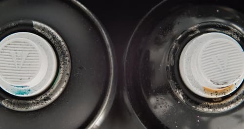 Overhead Shot Of Used Spray Paint Cans With Messy Valve Spray. close up