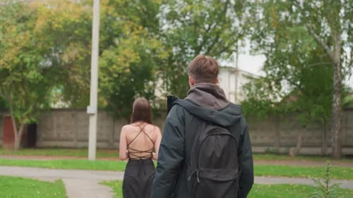 Young Couple Shares Emotional Embrace in Park with Teenager Nearby Casual Scene Captures Heartfelt