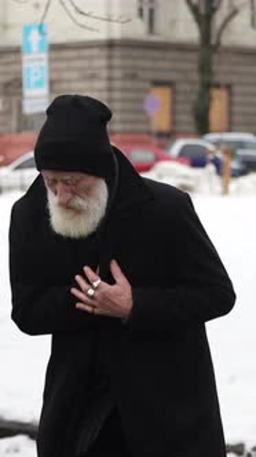 Man with White Beard Standing Outside in City