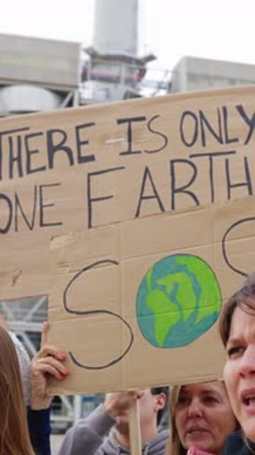 Groupe de différentes personnes brandissant des affiches pour protester contre le changement climatique