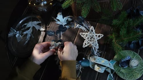 Hands Crafting Decorative Christmas Wreath at Home