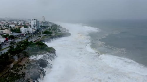 Aerial view of giant cyclone waves crashing and flooding the seafront of the city