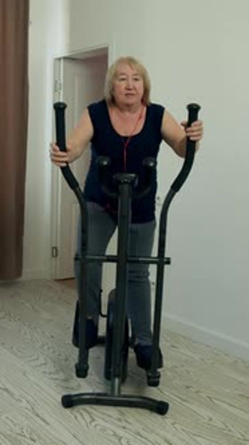 Active Senior Woman Exercising on Elliptical Machine