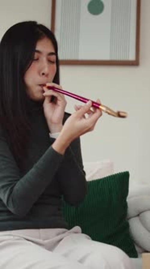 Woman Blows into Party Noise Maker at Home