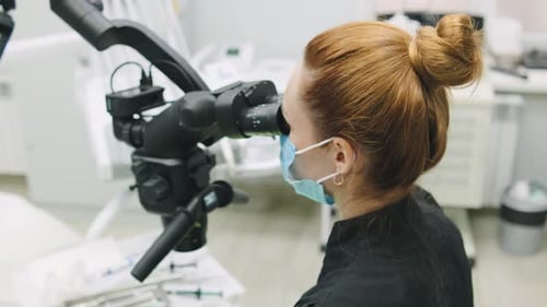 Dentist Using Microscope on Patient in Dental Clinic