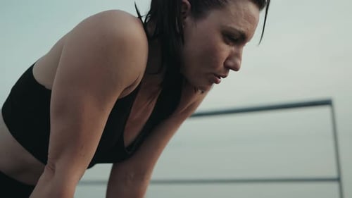 Tired Runner Woman Relaxing After Sunset Run Outdoors