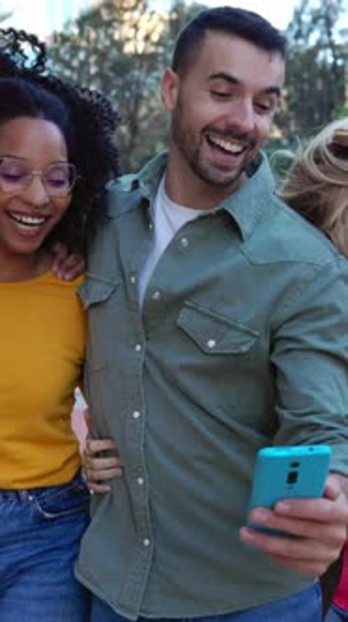 Three Young Friends Laughing at Phone