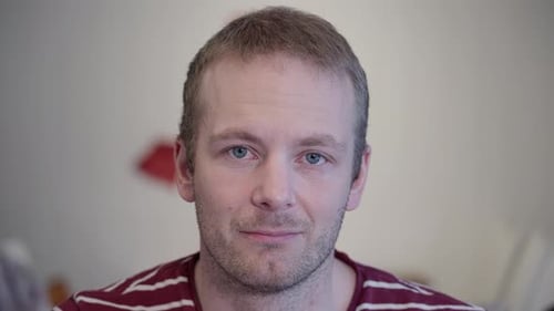 Man smiling and opening eyes in close up shot