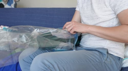 Person Packing Clothes into Vacuum Storage Bag