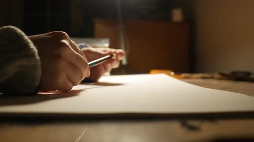 Creative crisis, hand holding colored pencil over blank paper, close up