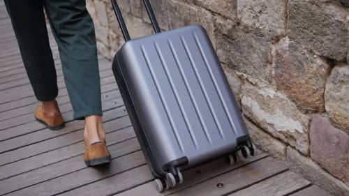 Tourist with Suitcase Baggage in Spain A Traveler with Luggage Strolls Down a Lively City Street to
