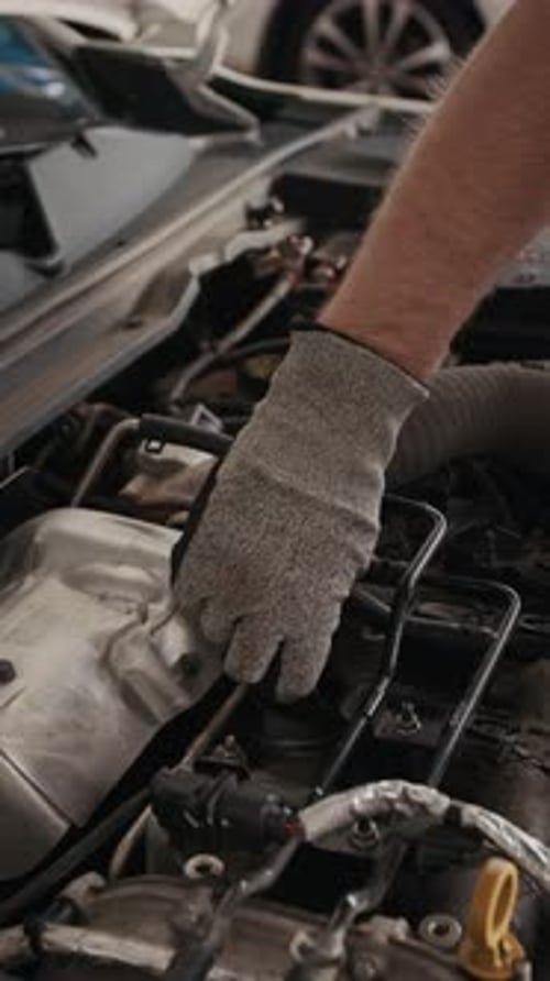 Hand of Anonymous Mechanic Removing Cap from Oil Tank in Car Engine