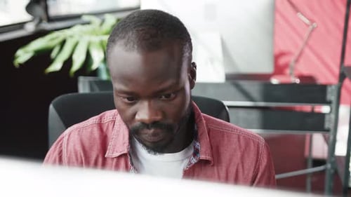 Man Reading Notebook at Desk in Office