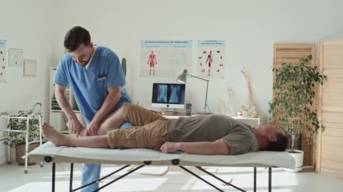 Physical Therapist Treating Patient's Knee in Clinic