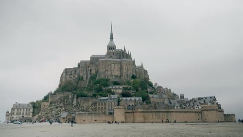 Mont St Michel - A massive, historic abbey sits atop a rocky island, surrounded by empty tidal flats
