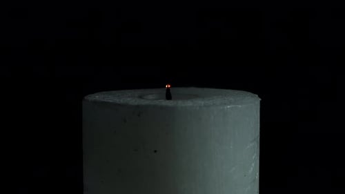 White Candle is Extinguished on a Black Background