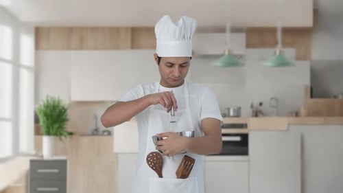 Young Adult Chef Mixing Ingredients in Kitchen