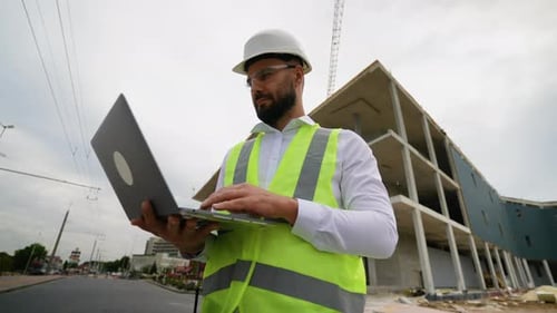 Bauleiter nutzt Laptop vor Ort