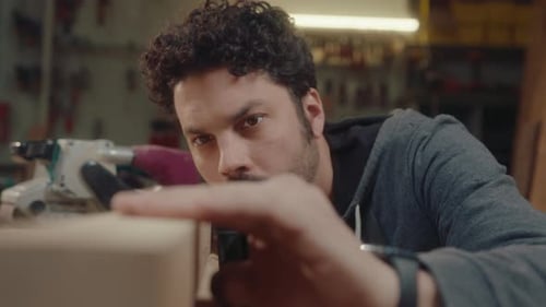 Woodworker Inspecting Plank of Wood in Workshop