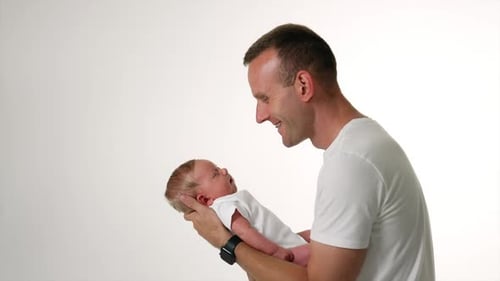 Loving Father Holds Infant in White Studio Setting