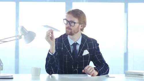 Young Adult with Paper Airplane at Workplace