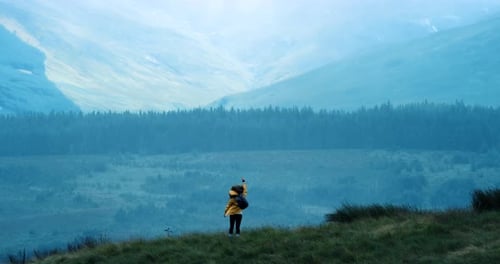 Woman Hiker on Grassy Hill With Mountain Views