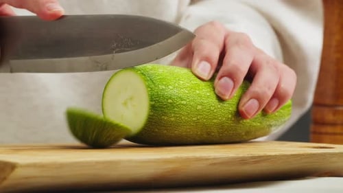 Cutting Green Zucchini on Wooden Desk with Knife Closeup Macro Slicing Squash Woman Hand Cut