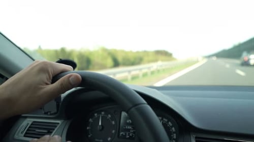 Mann fährt mit seinem Auto auf einer sonnigen Tagesreise eine Autobahn entlang
