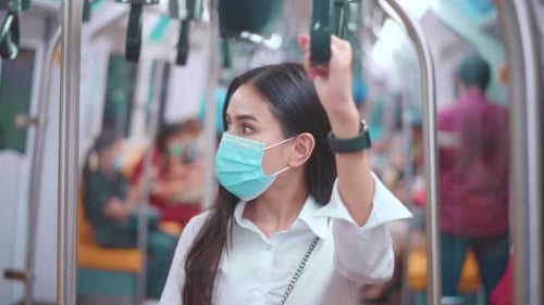 A young business woman is wearing face mask in public transportation