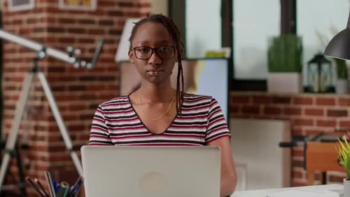 Woman Working on Laptop at Desk in Home Office