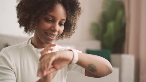 Woman Interacts with Smartwatch at Home During Daytime
