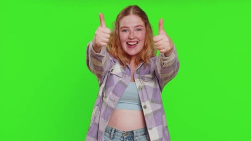 Young Woman Crossing Fingers and Celebrating Against Green Screen